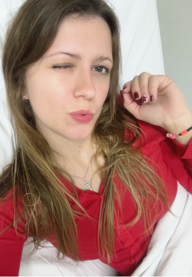 A girl in a red cardigan smiling